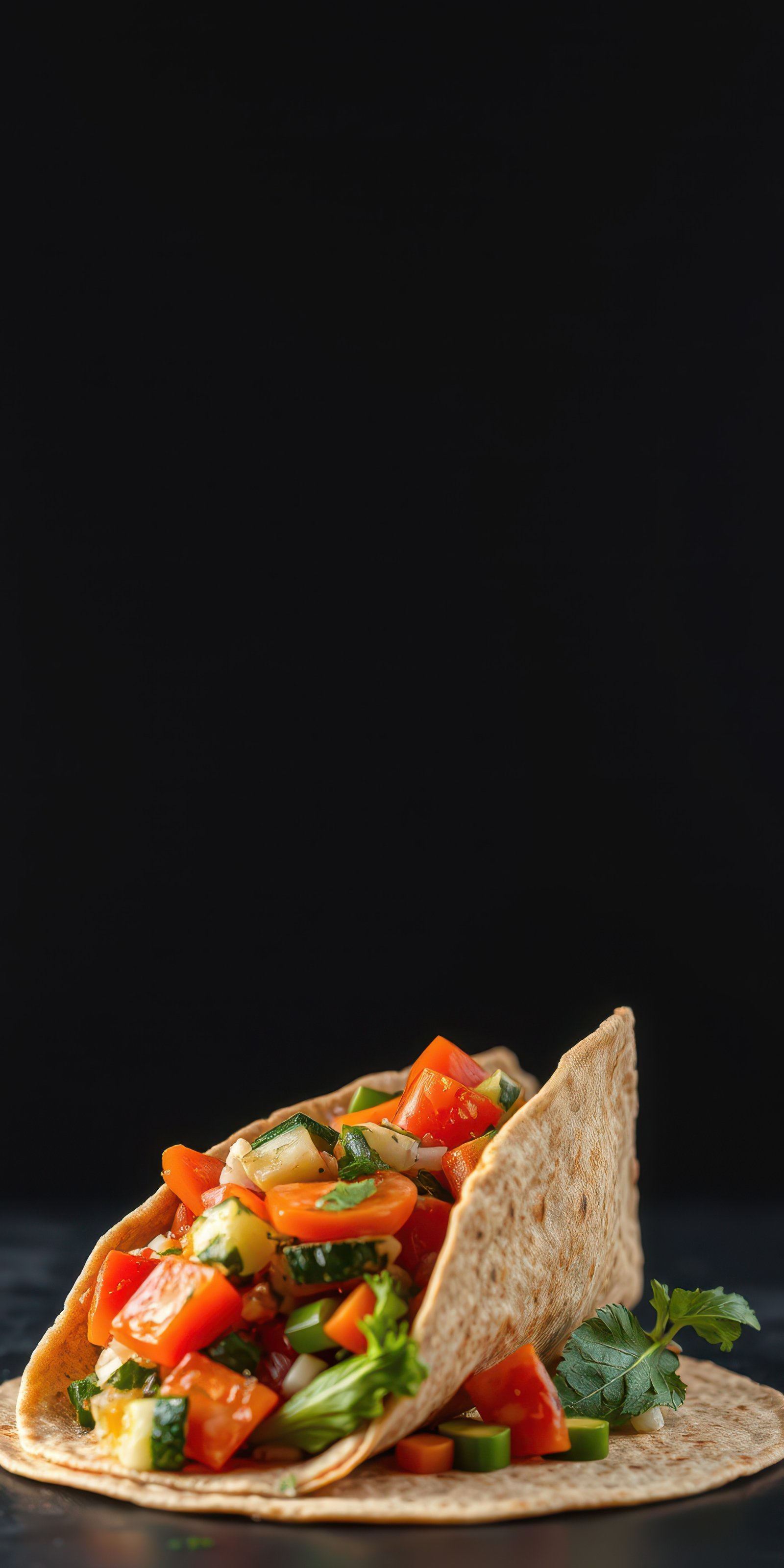 Colorful vegetable-filled wrap with fresh ingredients in a dark setting on a clean surface